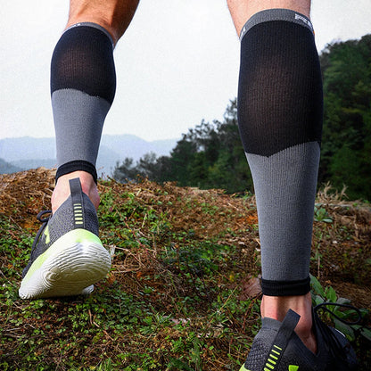 Person wearing black and gray compression sleeves on legs outdoors