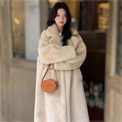 Woman wearing a long beige fur coat holding a brown handbag with a visible brand logo.