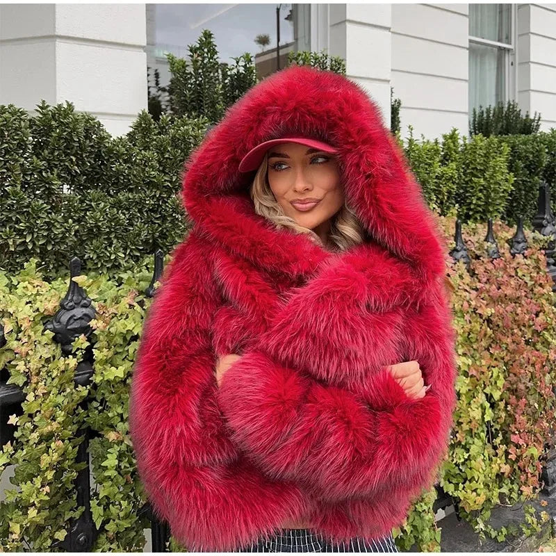 Person wearing a bright red fur coat and matching hat outdoors.