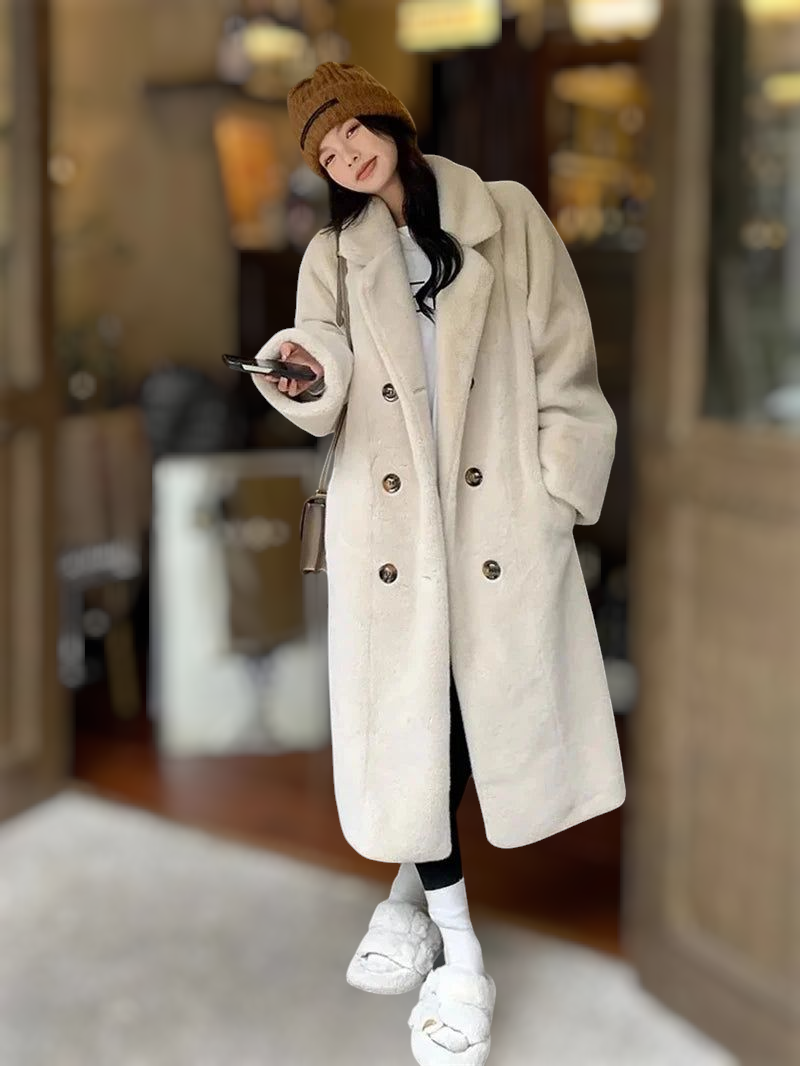Person wearing a long beige coat in an indoor setting