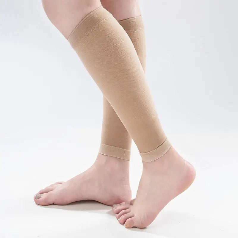 Beige compression stockings being worn on a white background