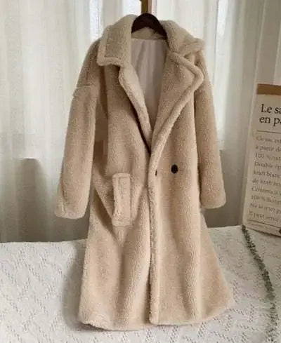 Beige teddy coat on a hanger against a neutral background