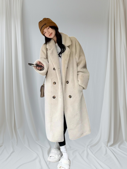 Person wearing a long beige coat, white sneakers, and a brown beanie against a plain background