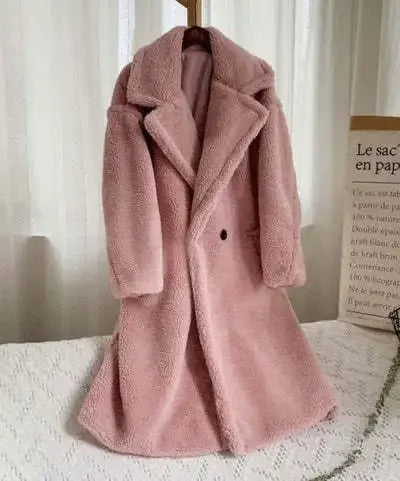 Pink teddy coat on a hanger against a neutral background