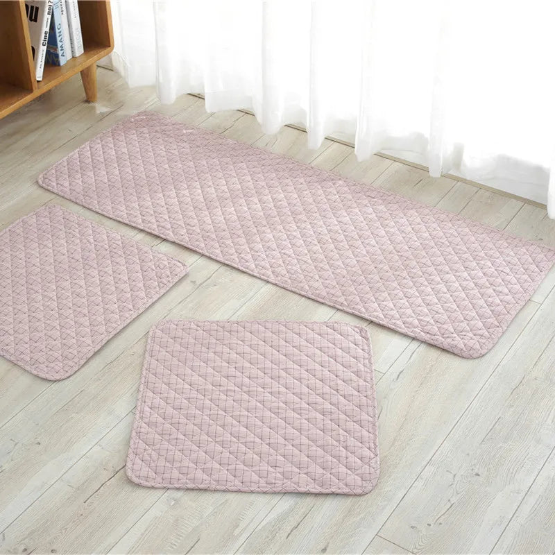Set of three pink textured rugs on a light wooden floor.