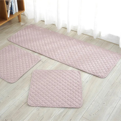 Set of three pink textured rugs on a light wooden floor.