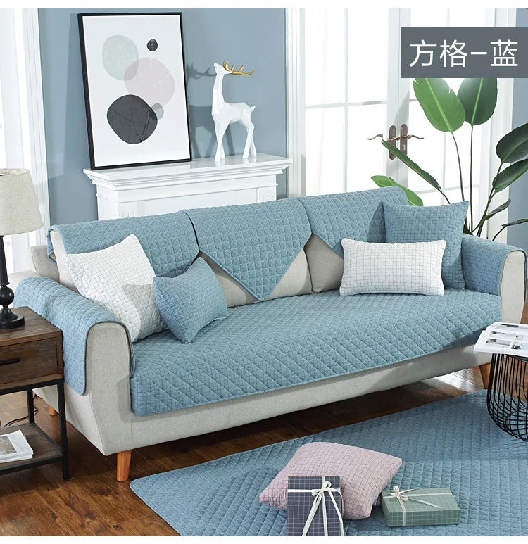 Blue sofa cover on a sofa in a living room with decor elements.