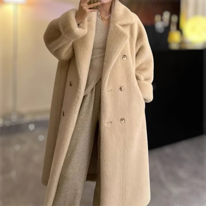 Beige overcoat worn by a person with a blurred indoor background